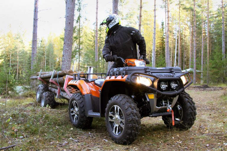 Mönkijä ja perävaunu tekemässä metsätöitä.