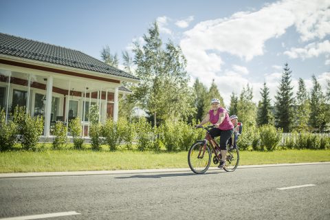 Aikuinen kuljettaa lasta polkupyörällä