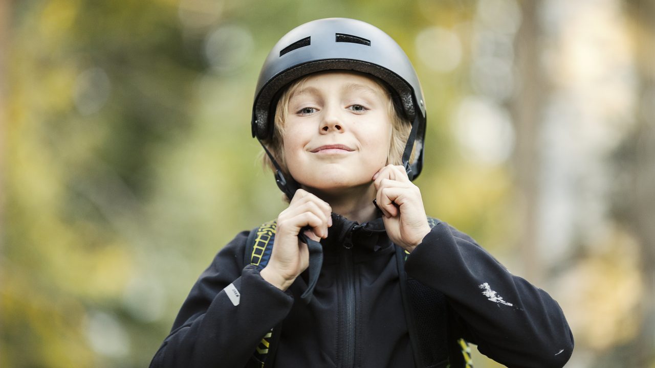 Lapsi laittaa pyöräilykypärää päähän