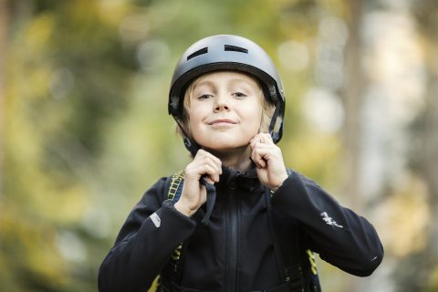 Lapsi laittaa pyöräilykypärää päähän