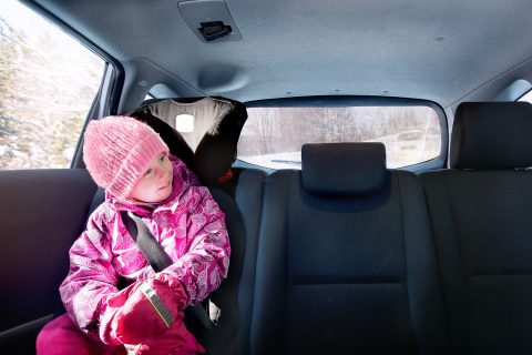 Lapsi istuu autossa turvaistuimessa