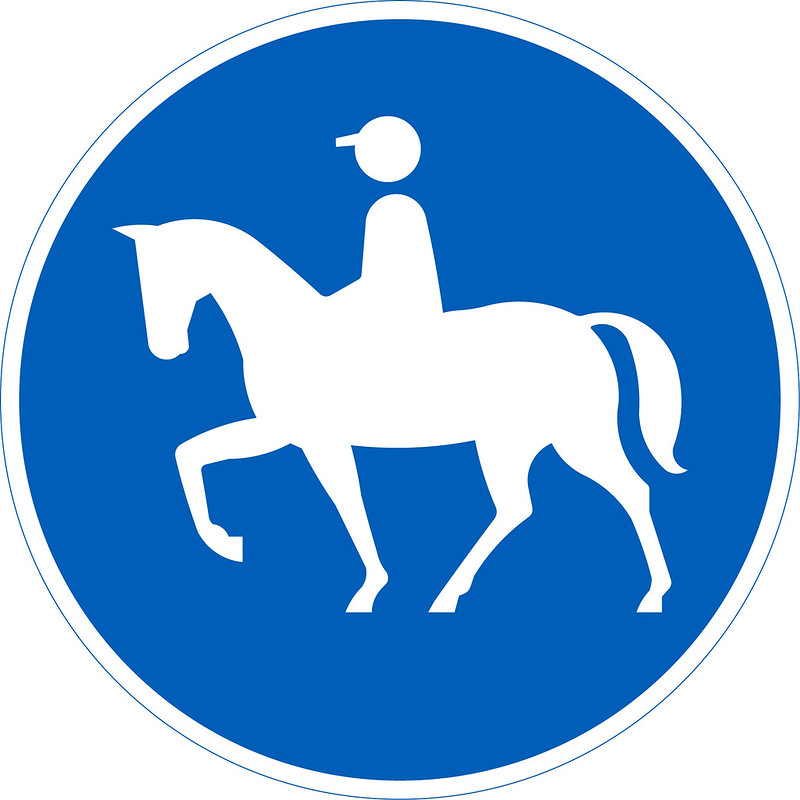Ratsastustie-liikennemerkki, jossa ratsastaja ja hevonen. 