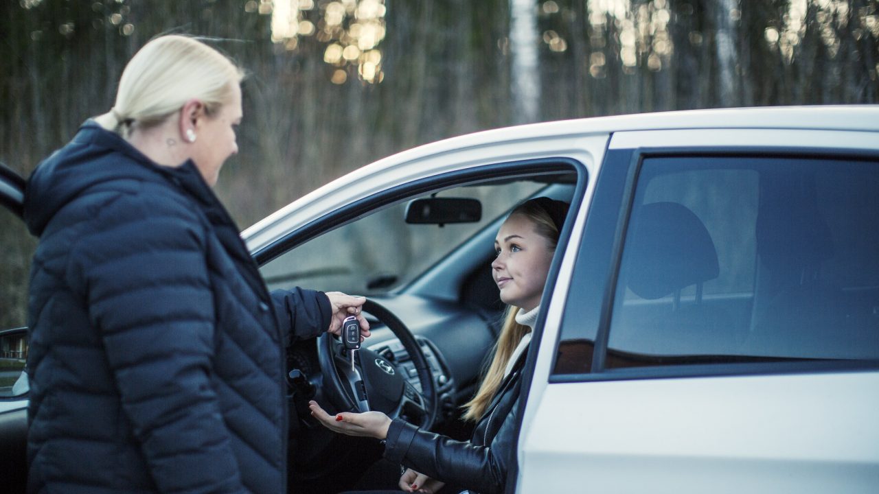 Äiti antaa auton avaimet lapselleen, joka istuu auton etupenkillä. Kuva: Nina Mönkkönen/Liikenneturva