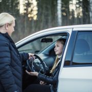 Äiti antaa auton avaimet lapselleen, joka istuu auton etupenkillä. Kuva: Nina Mönkkönen/Liikenneturva