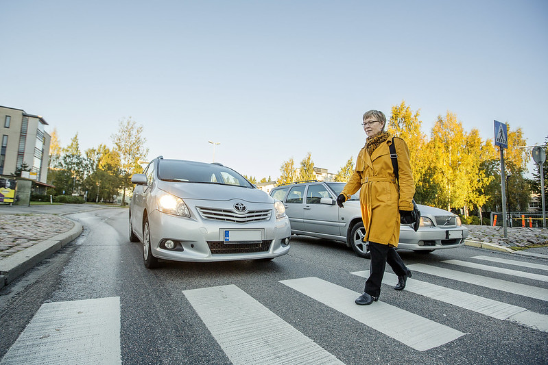 Jalankulkija ylittää suojatietä.