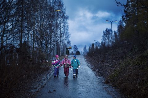 Lapset kävelevät tiellä heijastimet heiluen.