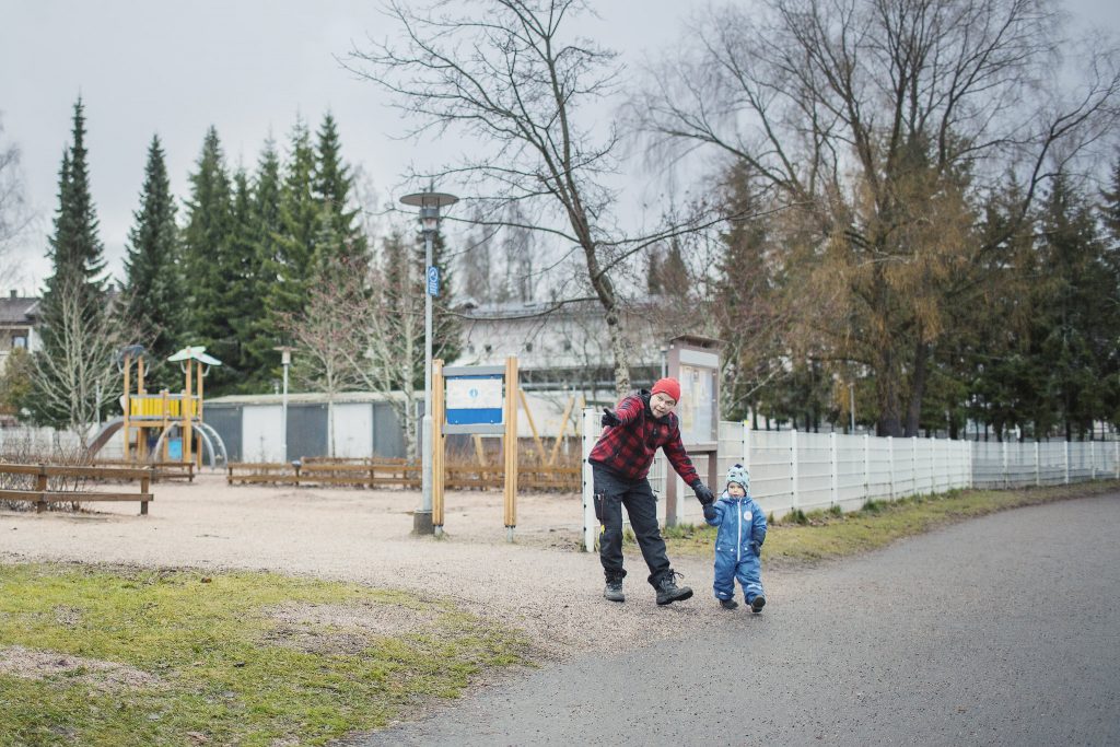 Isä opastaa lastaan liikenteessä.