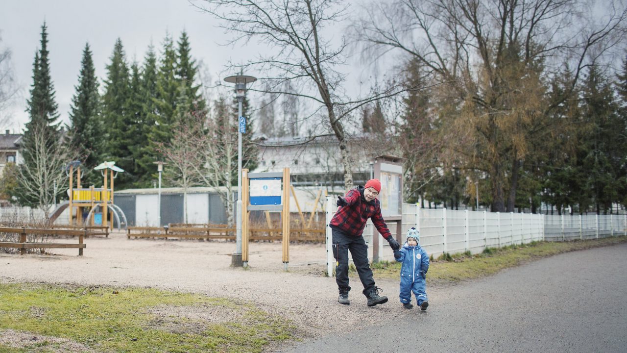 Isä opastaa lastaan liikenteessä.