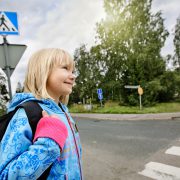 Koululainen pysähtyneenä suojatien eteen.