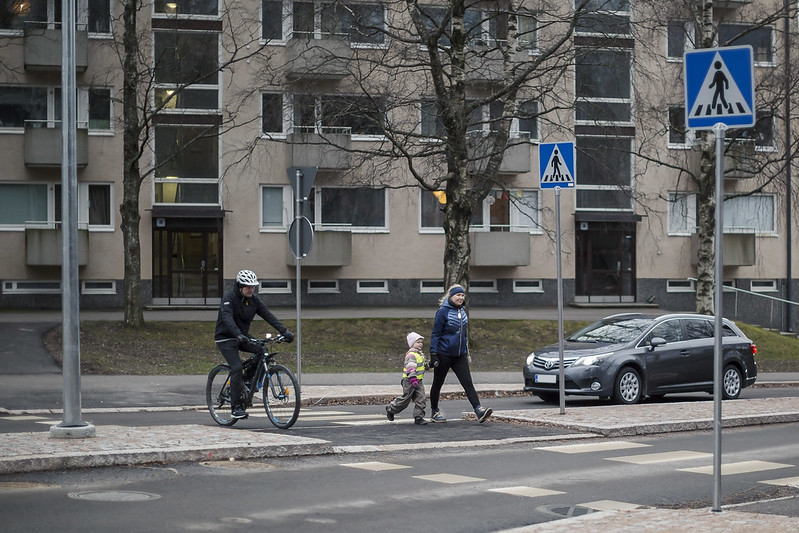 Autoilija poistuu liikenneympyrästä ja antaa tietä jalankulkijoille ja pyöräilijälle.