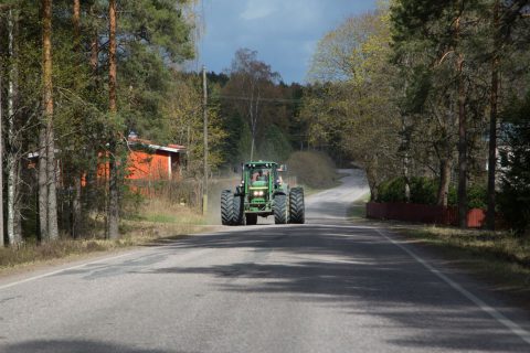 Traktori ajaa tein reunassa.