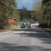 Leveä traktori ajaa maantiellä