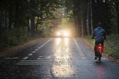 Autoilija harjaa lunta auton katolta.