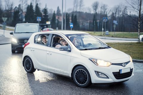 Kaksi autoa peräkkäin, joissa molemmissa palaa ajovalot.