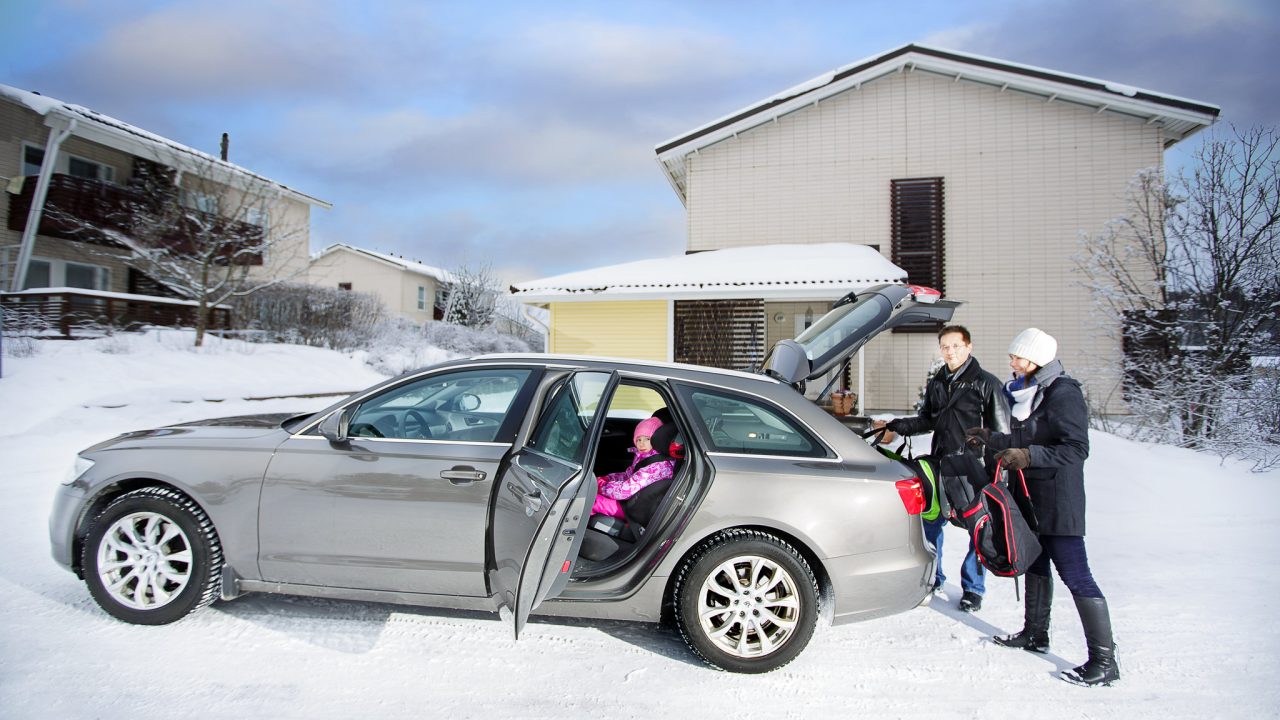 Perhe pakkaa autoaan hiihtolomamatkaa varten.