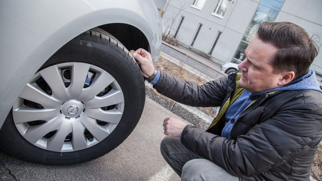 Renkaiden urasyvyyksien tarkistus kolikolla.