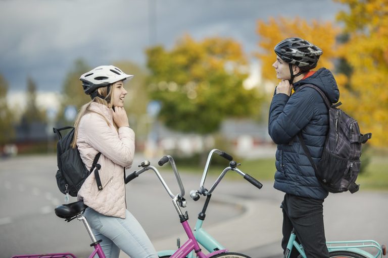 Nuoret laittamassa pyöräilykypäriä päähän.