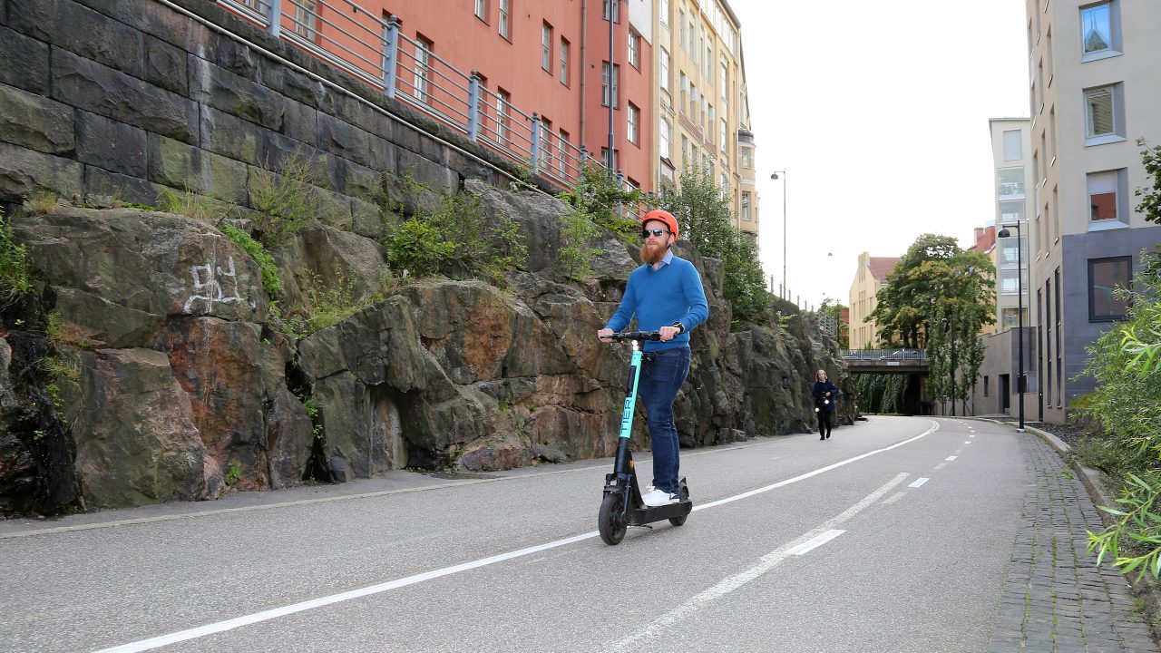 Sähköpotkulautailija ajaa baanalla.