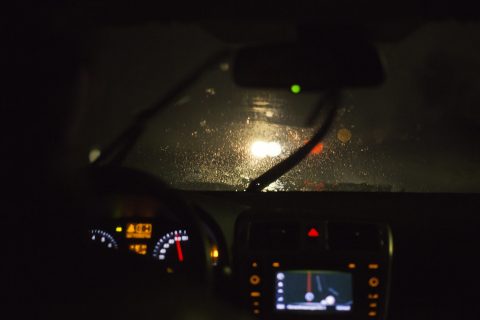 Sateinen ja pimeä ajokeli ratin takaa katsottuna.