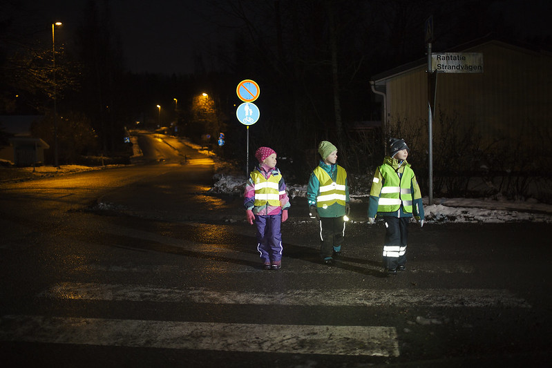 lapset ylittävät suojatietä heijastimet loistaen