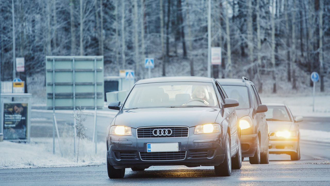 Kolme autoa ajaa jonossa liittymästä.