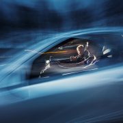 Autossa kuljettaja ja matkustajia.