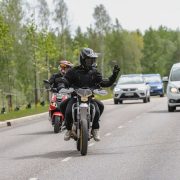 Mopoilija kiittää autoilijaa, joka antaa hänelle tietä.