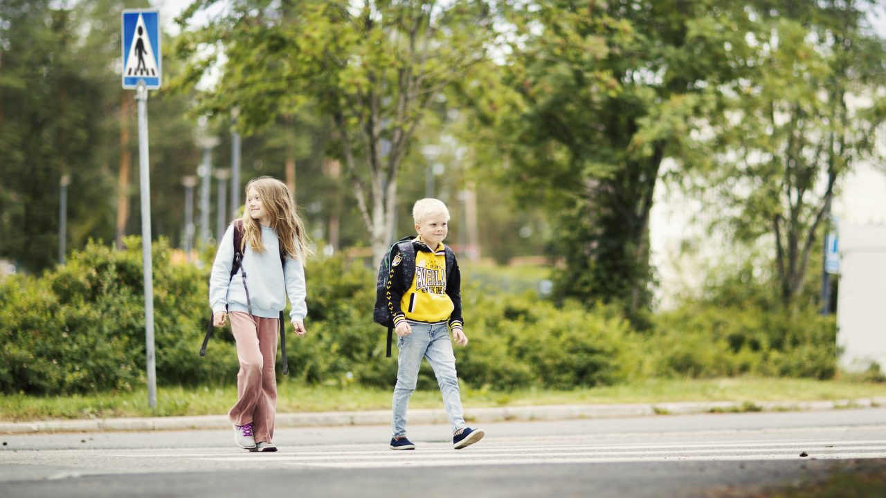 Koululaiset ylittävät tietä.