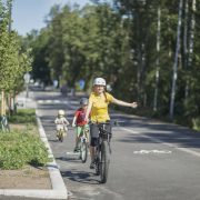 Huoltaja pyöräilee lasten