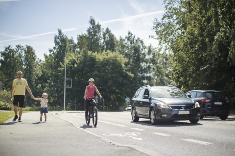 Jalankulkijat, pyöräilijä ja autoilija kulkevat kukin omilla väylillään.