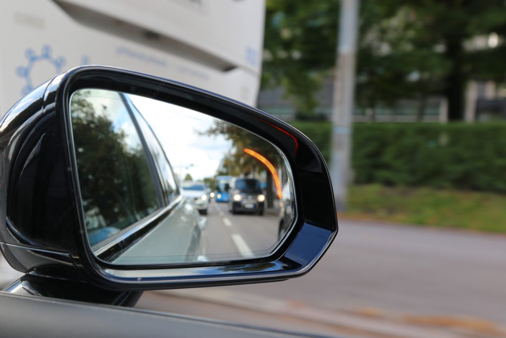 sivupeilissä näkyy keltainen valo koska auton kuolleessa kulmassa on toinen auto.