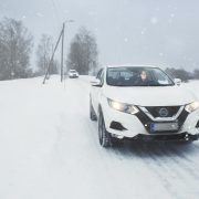 Kaksi autoilijaa ajaa peräkkäin talvisella tiellä.