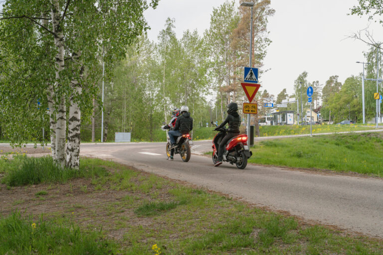Kaksi mopoa pysähtyneenä risteykseen.