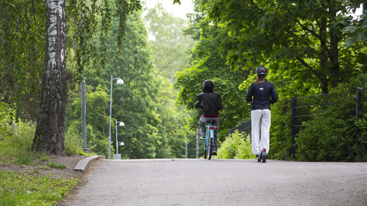Pyöräilijä ja sähköpotkulautailija ajavat samaan suuntaan.