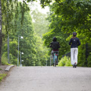 Pyöräilijä ja sähköpotkulautailija ajavat samaan suuntaan.