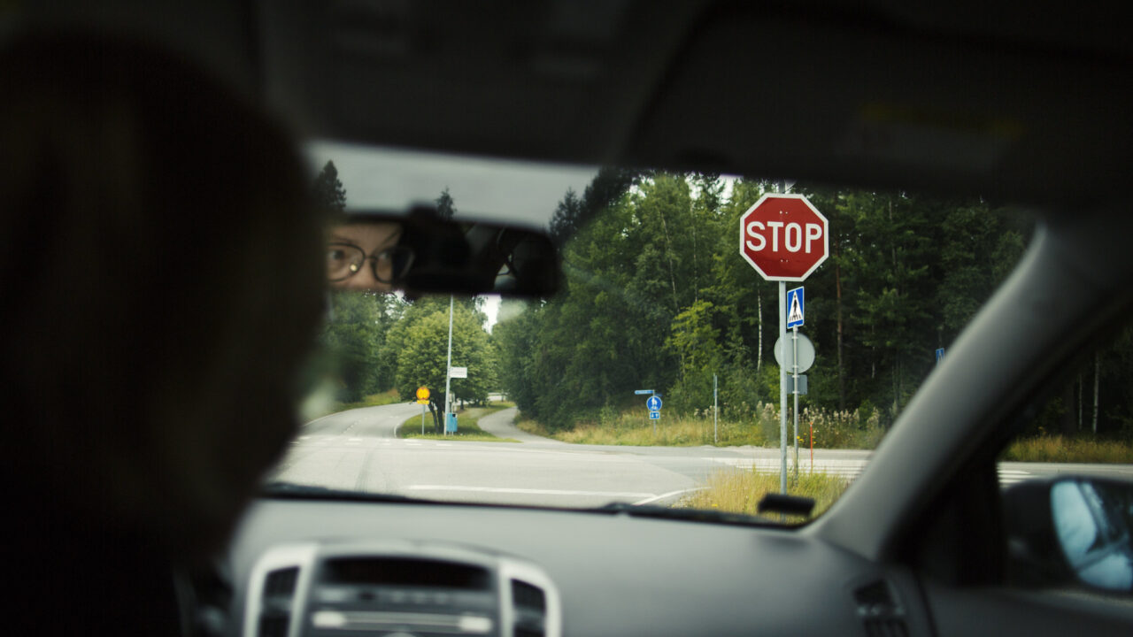 Autoilija pysähtyneenä stop-merkin eteen.