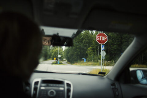 Autoilija pysähtyneenä stop-merkin eteen.