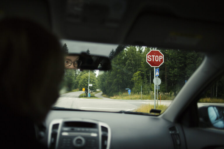Autoilija pysähtyneenä stop-merkin eteen.