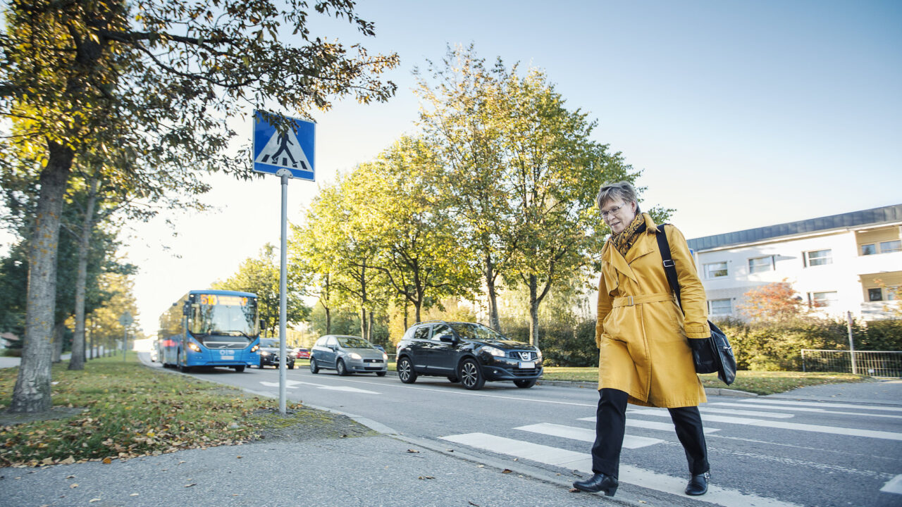 Kävelijä kävelee suojatietä pitkin työmatkallaan.
