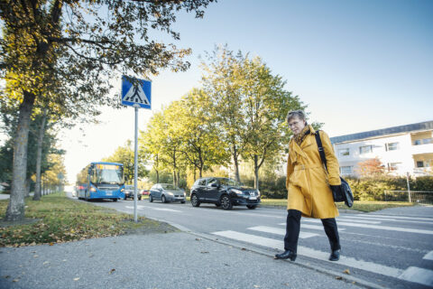 Kävelijä kävelee suojatietä pitkin työmatkallaan.