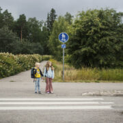 Kaksi koululaista suojatien edessä.