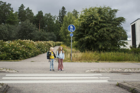 Kaksi koululaista suojatien edessä.